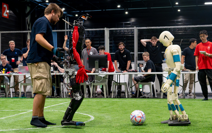 Sweaty mit einem Teammitglied und einem gegnerischer Roboter auf dem Platz